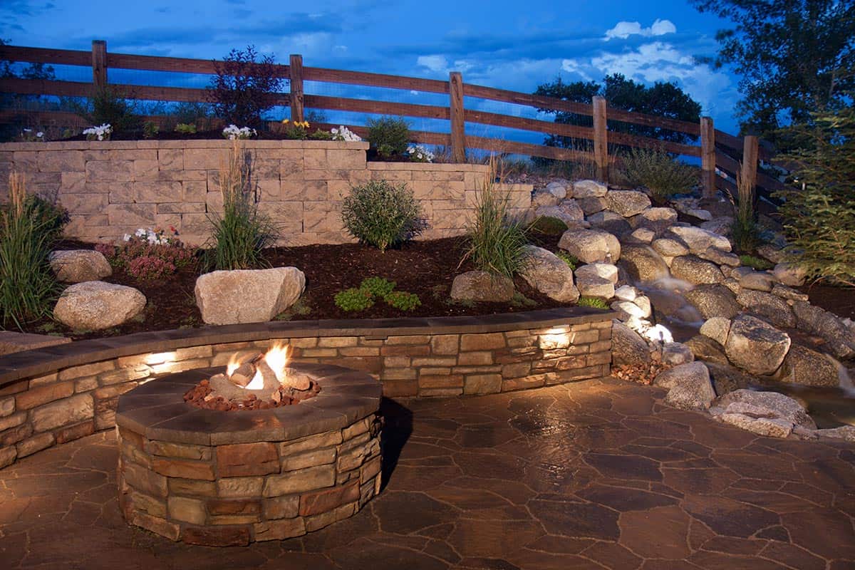 An amazing and beautiful backyard fire pit, seat wall and water feature