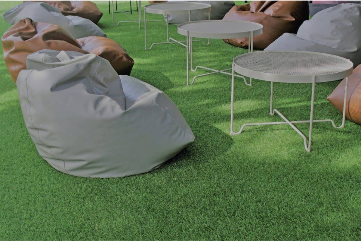 Bean bags and coffee tables in a sunlit garden on artificial turf