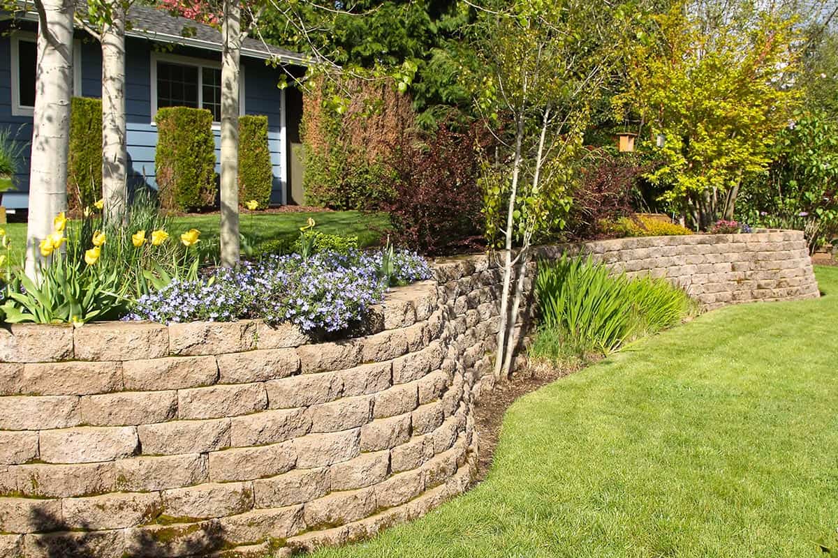 Cobblestone retaining wall in landscaped yard