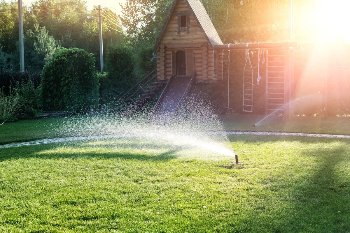 Landscape automatic garden watering system with different sprinklers installed under turf