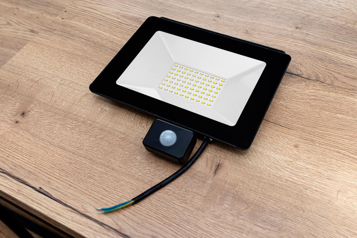 Outdoor LED lamp with a motion sensor composed of seventy LEDs lying on a table with cut cables