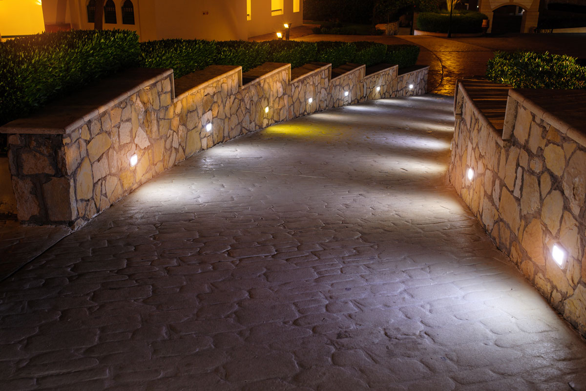 Stone driveway with wall lamps for lighting on the driveway