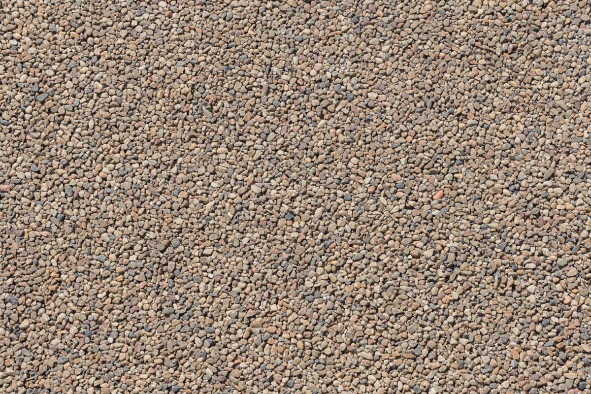 Texture of brown pea gravel rock, street background