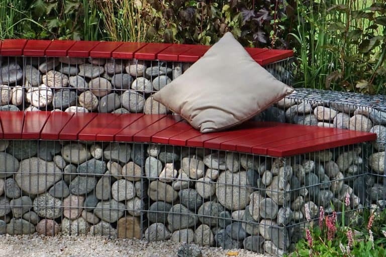 red wood of wall bench, rock, pebble foundation, metal brace, square pillow, garden at backyard, How To Build A Retaining Wall Bench Seat