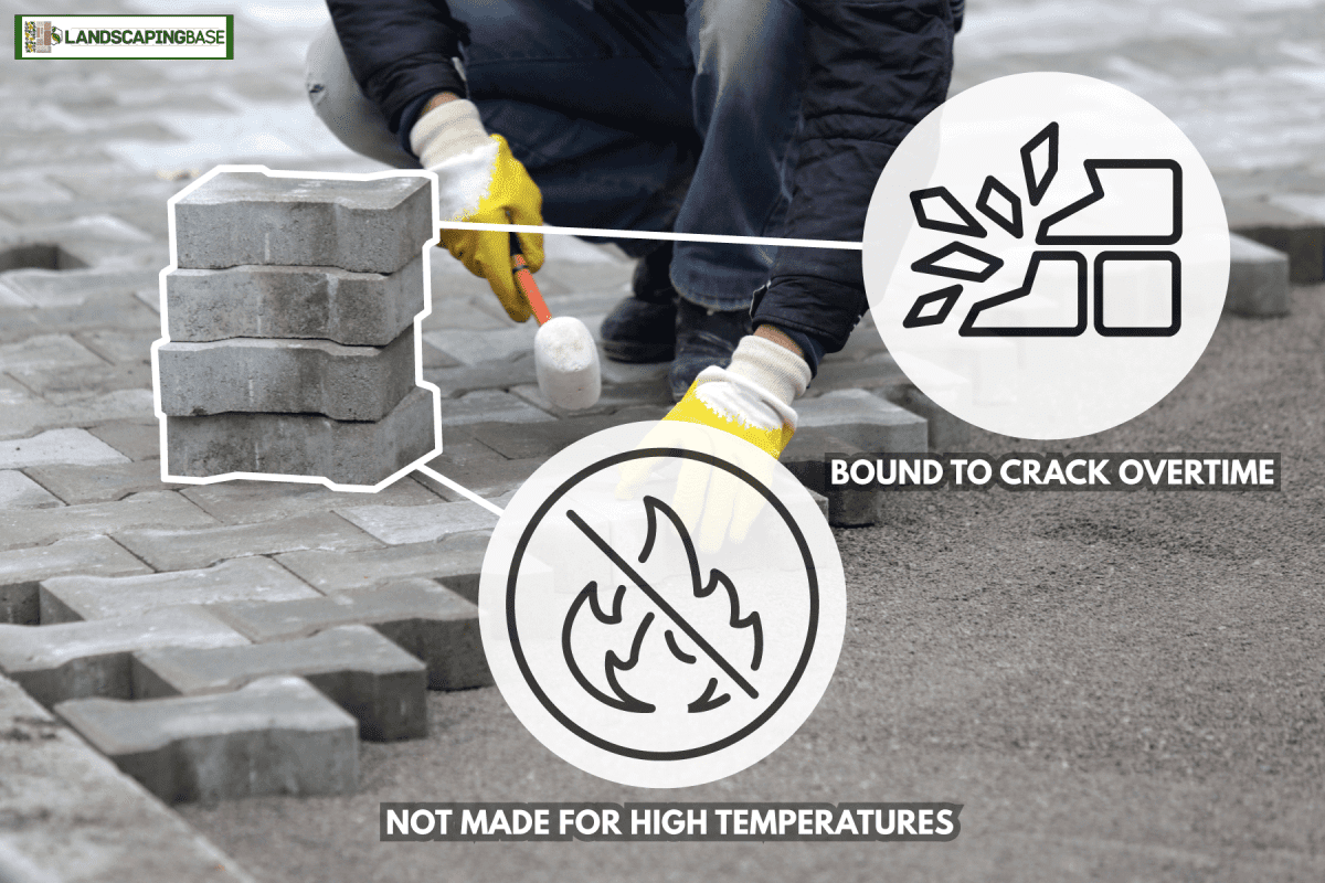 man wearing yellow safety gloves, holding rubber mallet, installing concrete pavers, Are Concrete Pavers Fireproof Or Fire Resistant?
