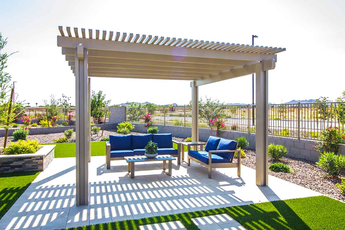 Back yard pergola covering blue cushion patio furniture