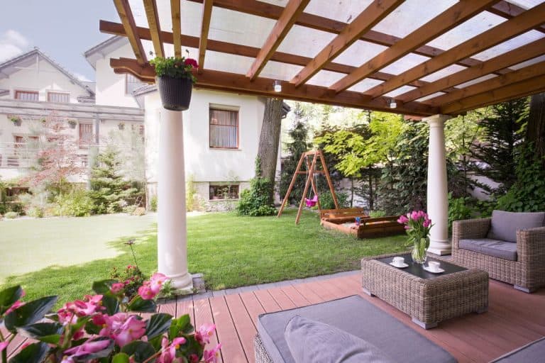 Beautiful farmhouse with attached pergola. Early spring- Do Pergolas Need To Be Anchored?