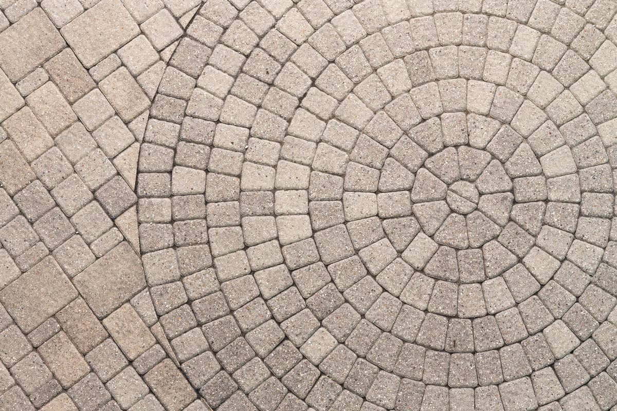 top view photo of a circular patio paver pattern idea on the driveway of the house