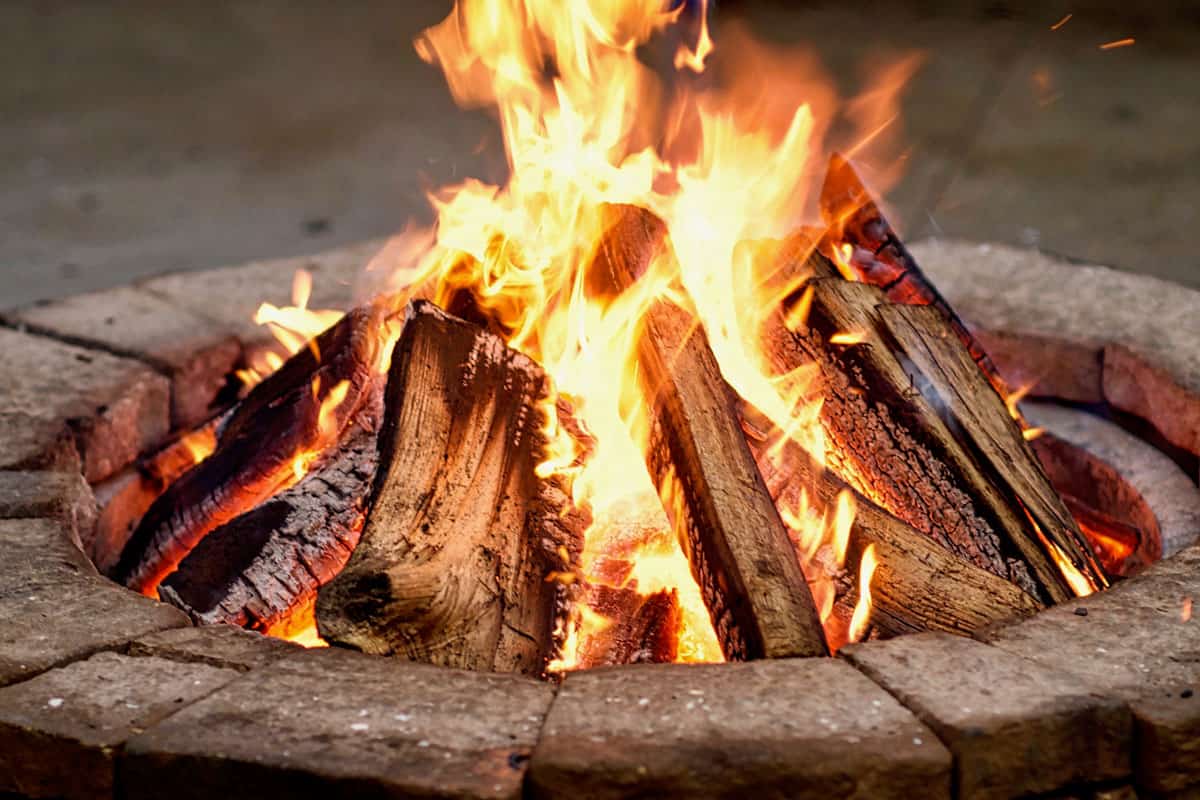 up close photo of a fire pit, strong bright fire, fire woods burning, fire pit blocks