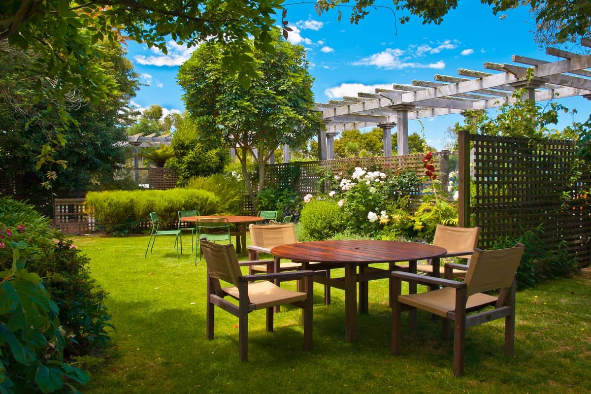 Build an Outdoor Patio - Landscaped Garden with Wooden Dining Table Set in the Shade of Trees